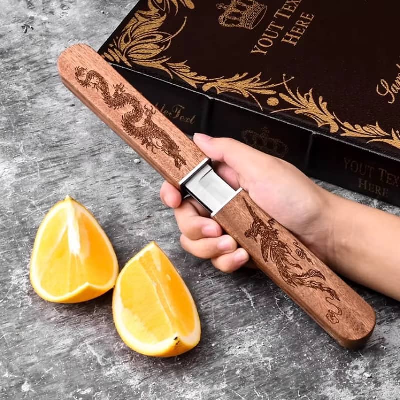 Couteau japonais traditionnel Tanto avec manche en bois gravé dragon, double lame dissimulée, présenté avec coffret élégant sur fond gris avec quartiers d'orange