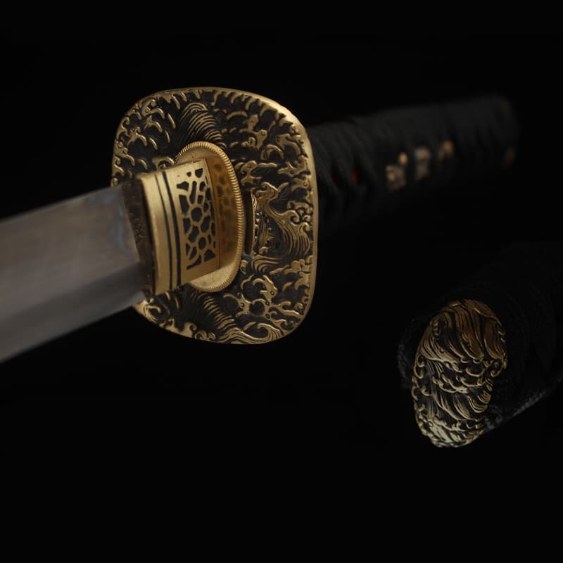 Garde en laiton finement gravée du katana japonais “Okinawa” en acier T10 trempé à l’argile.