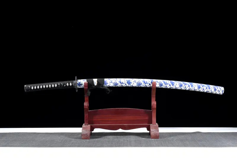 Katana japonais Tomoe Gozen en acier carbone plié 880 couches, avec saya blanc décoré de motifs bleus et finition pourpre.