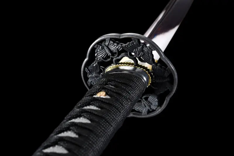 Détail de la garde tsuba noire du katana japonais Tomoe Gozen, poignée traditionnelle tsuka noire en coton et faux cuir.