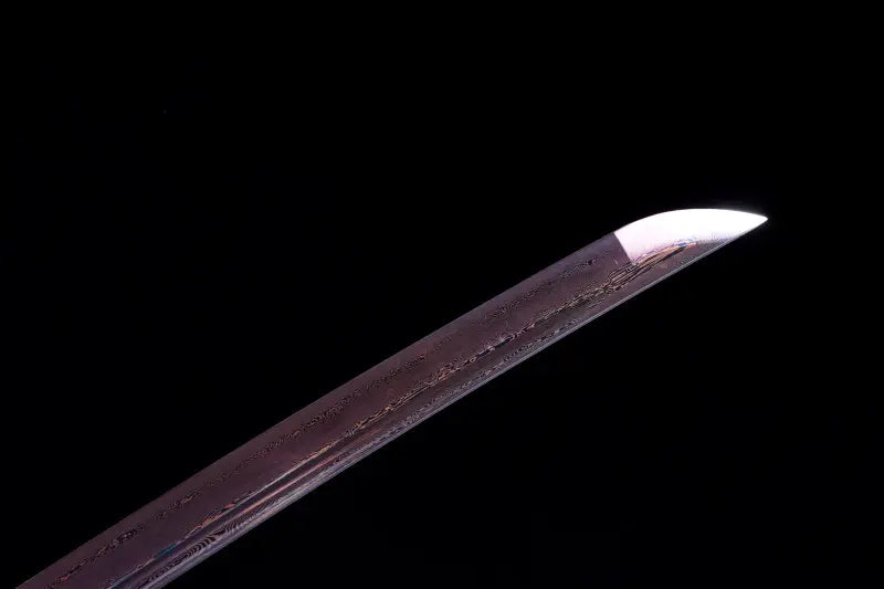 Pointe de la lame du katana japonais Tomoe Gozen en acier carbone plié, finition pourpre avec veinures décoratives.
