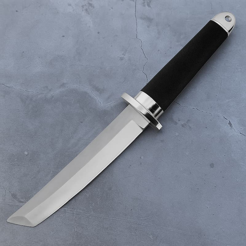 Tanto japonais moderne en acier 440C avec manche noir antidérapant posé sur fond béton gris.