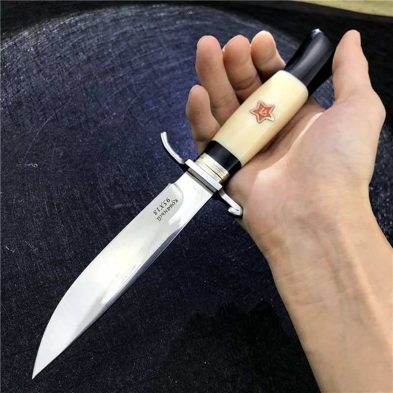 une main qui tien le Couteau de survie russe