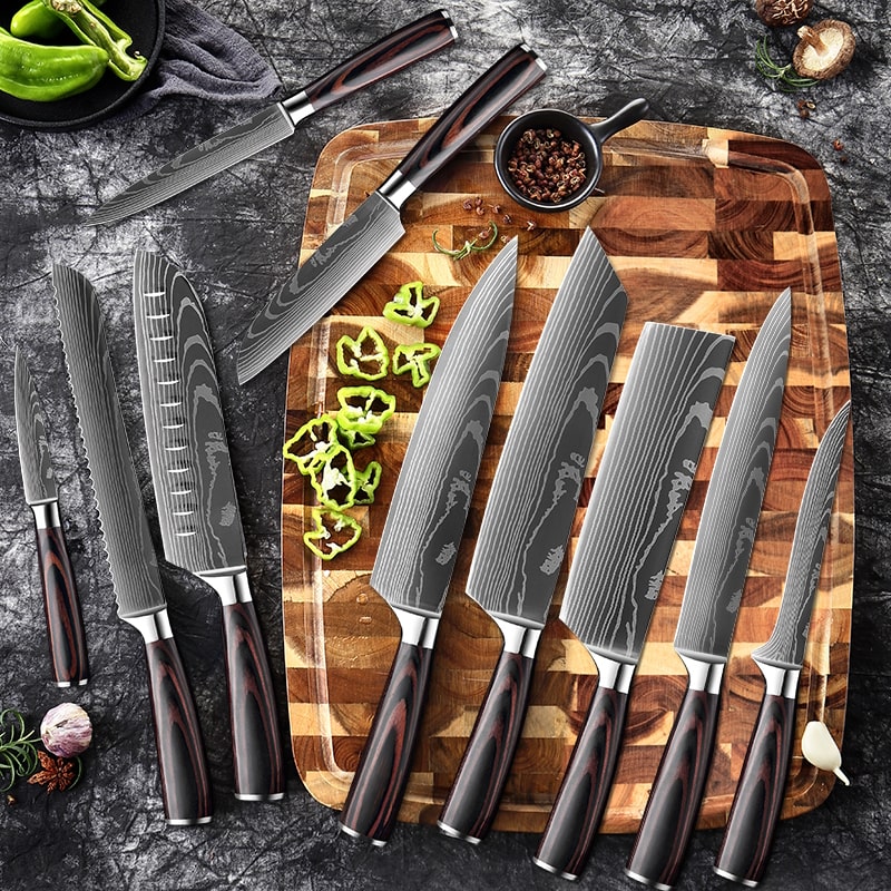 Ensemble de couteaux de cuisine japonais professionnel acier damas posé sur une planche a découpé en bois avec des légume 