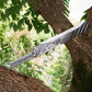 Machette style Heroic fantasy en acier lame full tang dans un arbre dans la nature