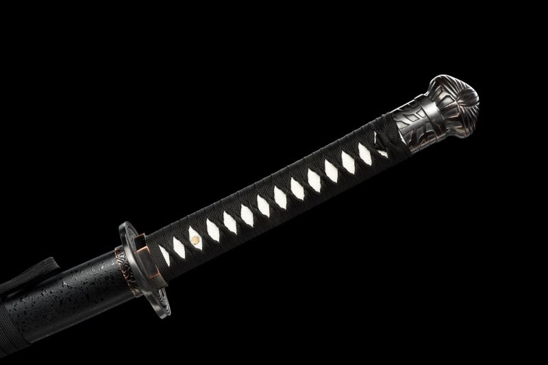 image sur fond noir du Manche du katana moonveil cosplay du jeu video Elder ring de couleur noir et blanc avec des corde tressé de couleur noir et un pommeau soigneusement décoré avec une grande qualité du détail   