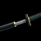 Katana entièrement rangé dans son fourreau noir avec embout doré, posé à plat.