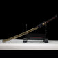 Katana japonais “Okinawa” en acier T10 trempé à l’argile, présenté avec son fourreau doré sur support.