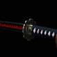 Gros plan sur la garde en forme de fleur et la lame noire et rouge du katana japonais Shusui en acier carbone 1045, réplique Roronoa Zoro.