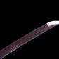 Pointe de la lame du katana japonais Tomoe Gozen en acier carbone plié, finition pourpre avec veinures décoratives.