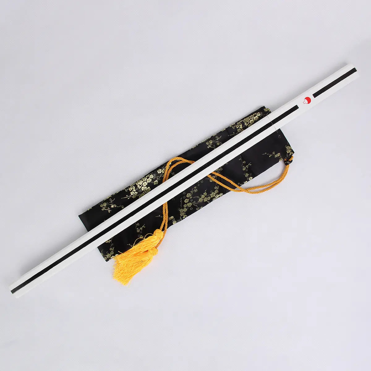 Katana Sasuke Uchiwa Kusanagi de Naruto avec fourreau blanc orné de l’emblème Uchiwa, posé sur une housse en soie noire à motifs dorés avec cordon jaune, réplique en acier carbone 1045 haut de gamme idéale pour cosplay et collection.