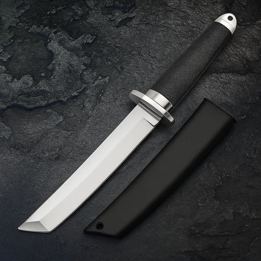 Tanto japonais tactique en acier 440C avec manche noir texturé et étui rigide assorti sur fond pierre sombre.