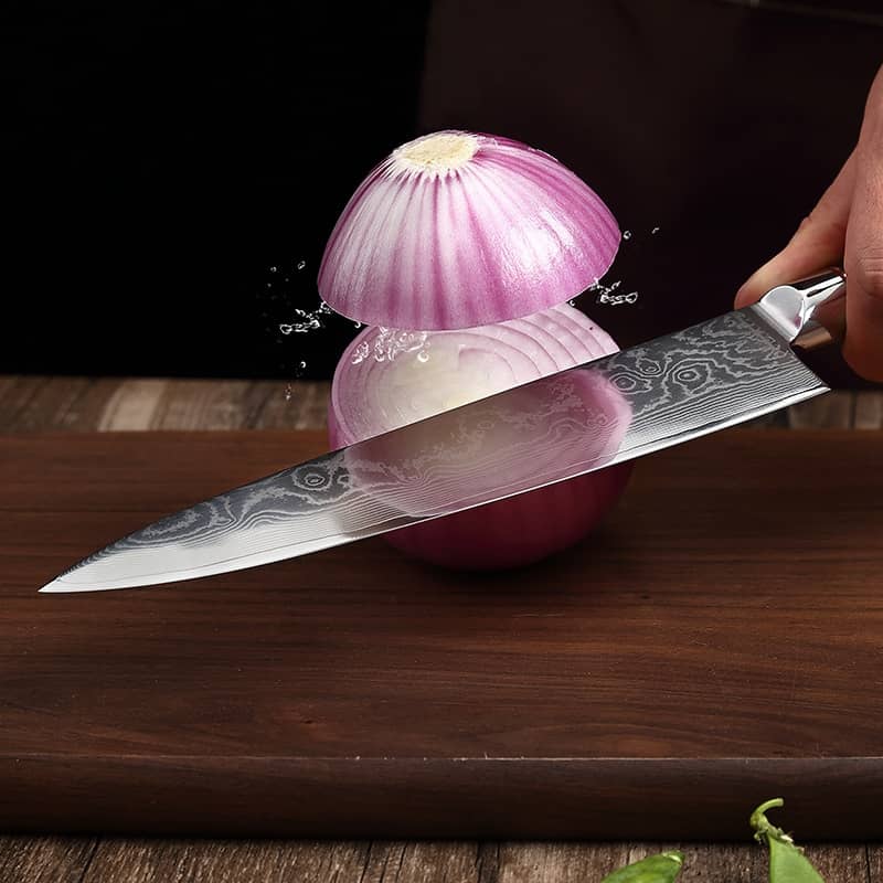 Couteau de cuisine japonais en acier damas qui tranche un ognion