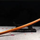 Katana de samurai Shirasaya en bois de rosier lame courbée dans son saya posé sur socle